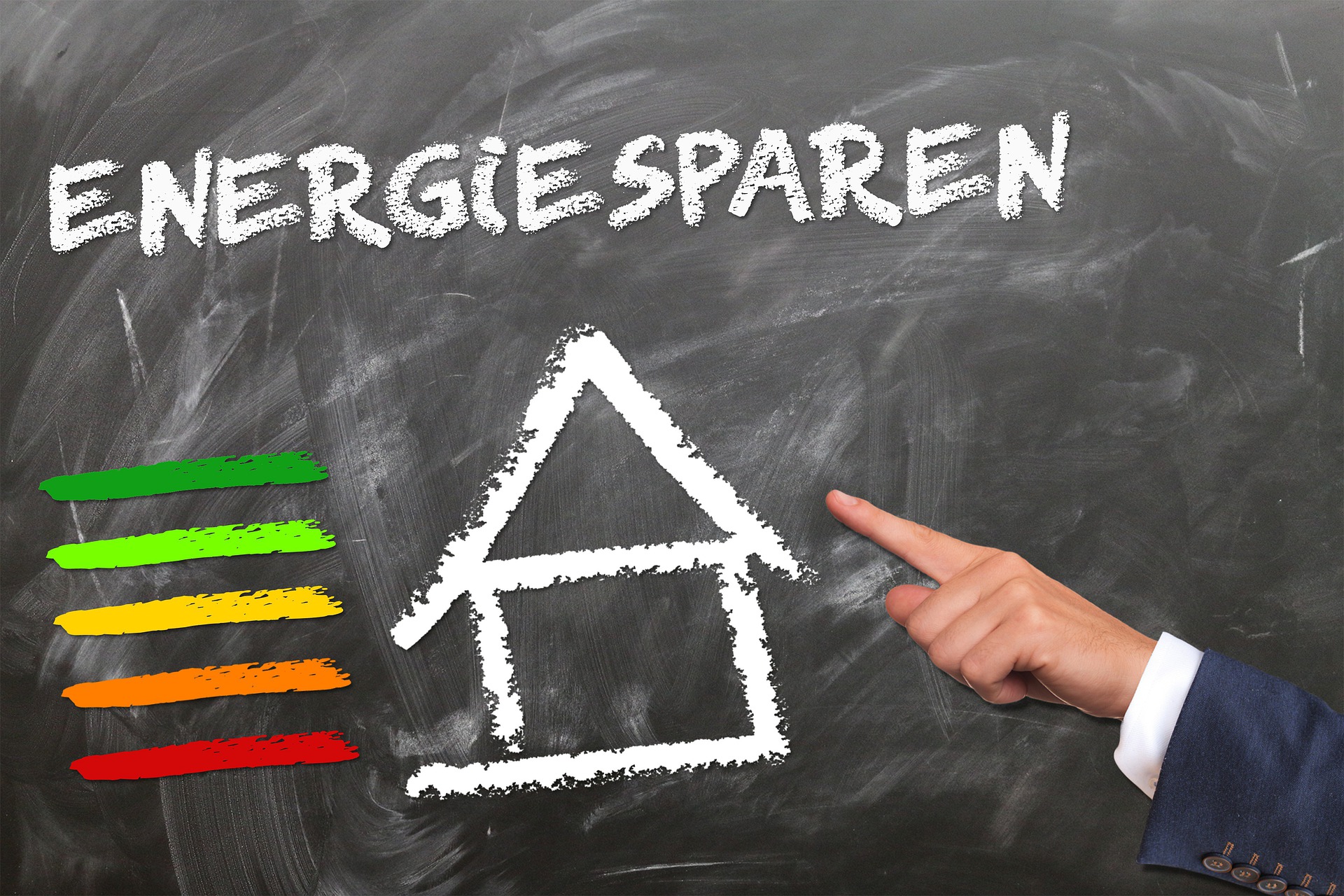 Tafel mit der Aufschrift „Energie sparen“, einem gezeichneten Haus und einer Farbskala zur Energieeffizienz